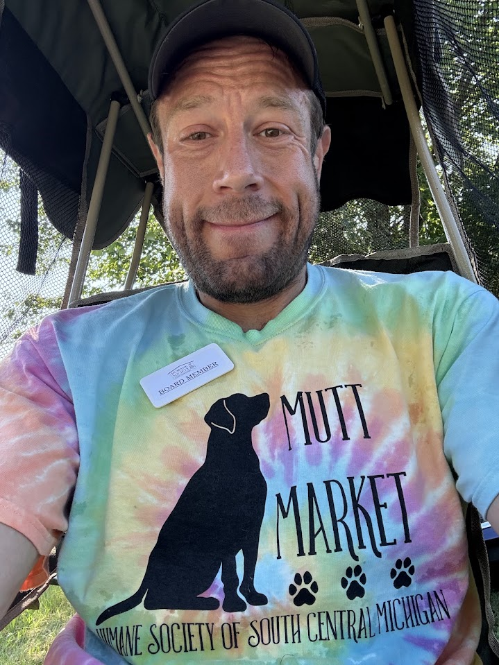 Chris Brennan volunteering at HSSCM’s Mutt Market in a board member shirt